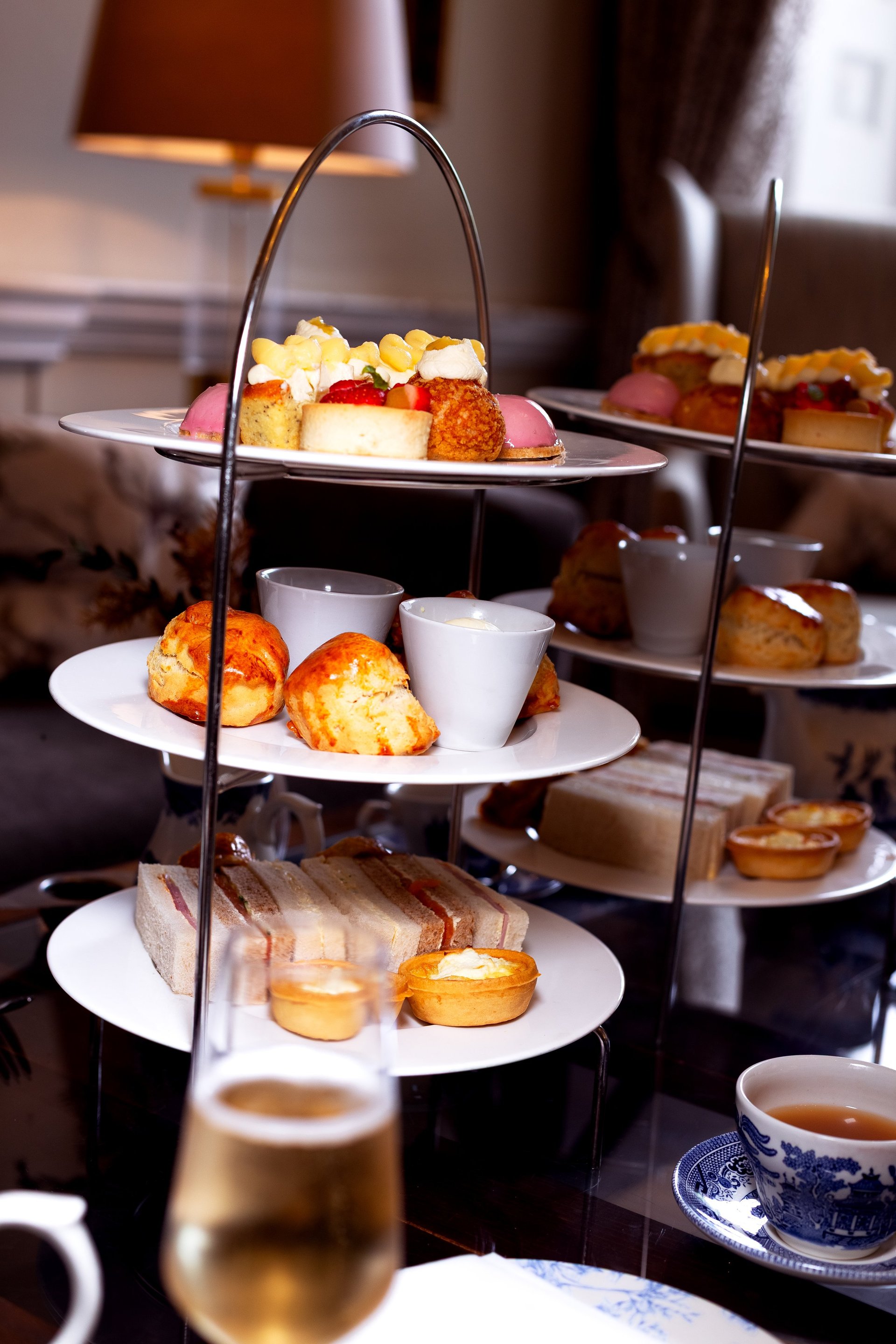 Classic afternoon tea with finger sandwiches, scones with clotted cream and jam, cakes and pastries with a pot of English breakfast tea